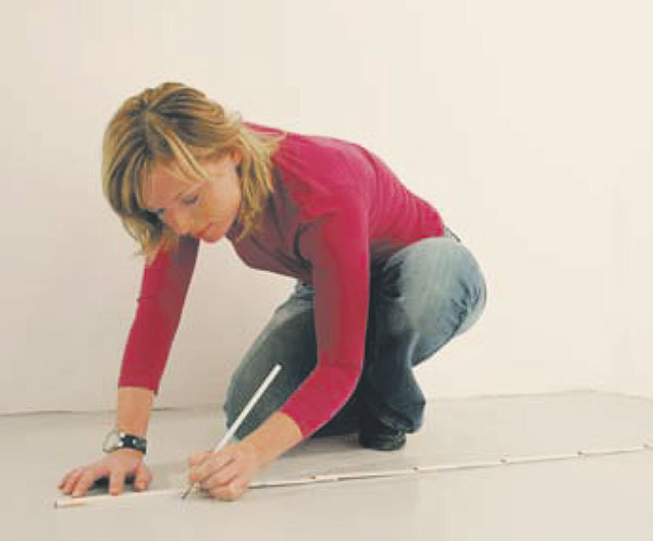 Na podlahe si vymerajte polohu priečky. Následne si „brnkacou šnúrou“ vyznačte obrysovú čiaru. Nezabudnite na prípadné dverné otvory. Potom si pomocou vodováhy a pravítka vyznačte obrysové línie priečky na stenách a stropoch. 