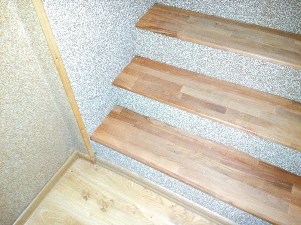 Na prechody medzi povrchmi som využil lišty z tvrdého dreva. Spodok schodov je obložený parketovou lištou. Celkom nakoniec pripevníme na steny nárožné lišty, ktoré ochránia steny pri často využívanom schodisku.