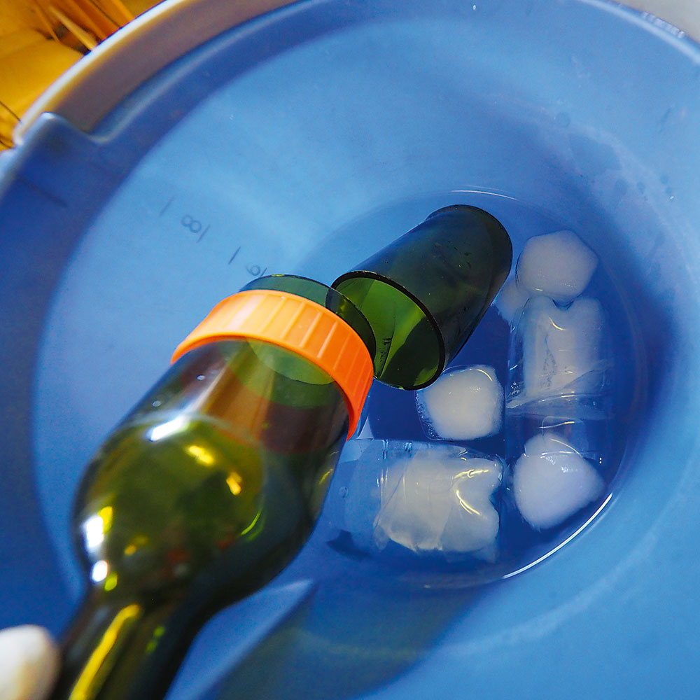 Studený kúpeľ. Nahriatu fľašu následne ponorte do studenej vody, kde sa pnutím fľaša rozdelí na dve časti. Ak to nevyjde na prvýkrát, opakujte nahriatie horúcou vodou.