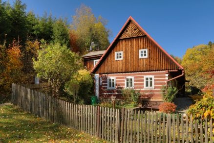 Klasická chata s dreveným plotom