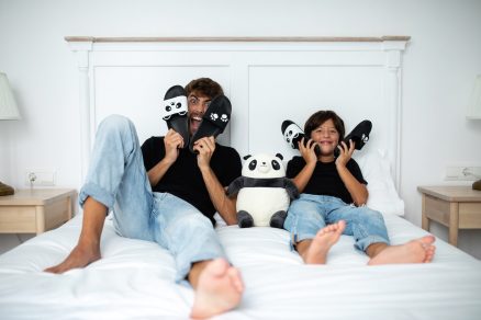 Muž a chlapec v posteli s panda šľapkami