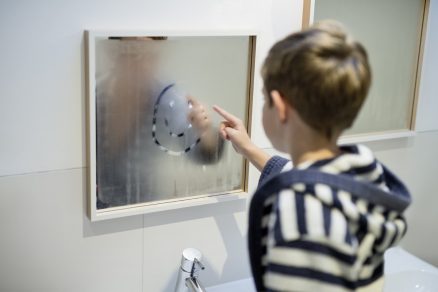 Chlapec maľuje na zarosené zrkadlo