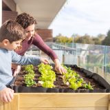 Žena so synom sadí rastlinky na terase