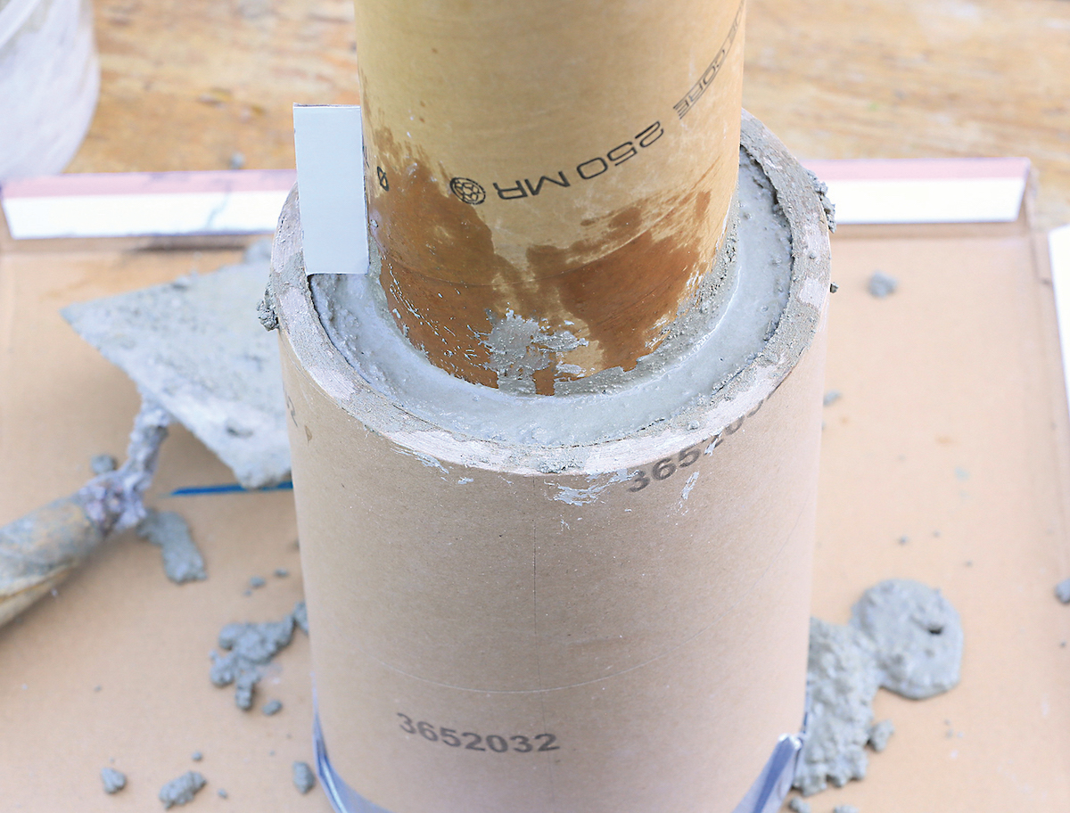 Vo vedre zarobte betónovú zmes s vodou. Mala by byť stredne hustá. Betón vylejte do širšej rolky a zatlačte do nej užšiu rolku tak, aby bola od dna asi 2 cm.