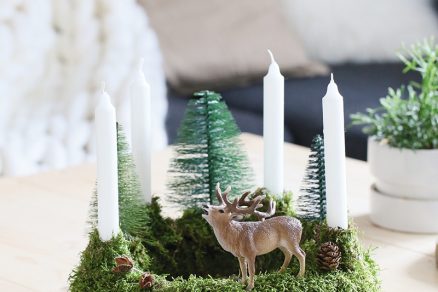 Zdobenie adventného venca vianočnými dekoráciami v tvare jeleňa, stromčekov a šišiek