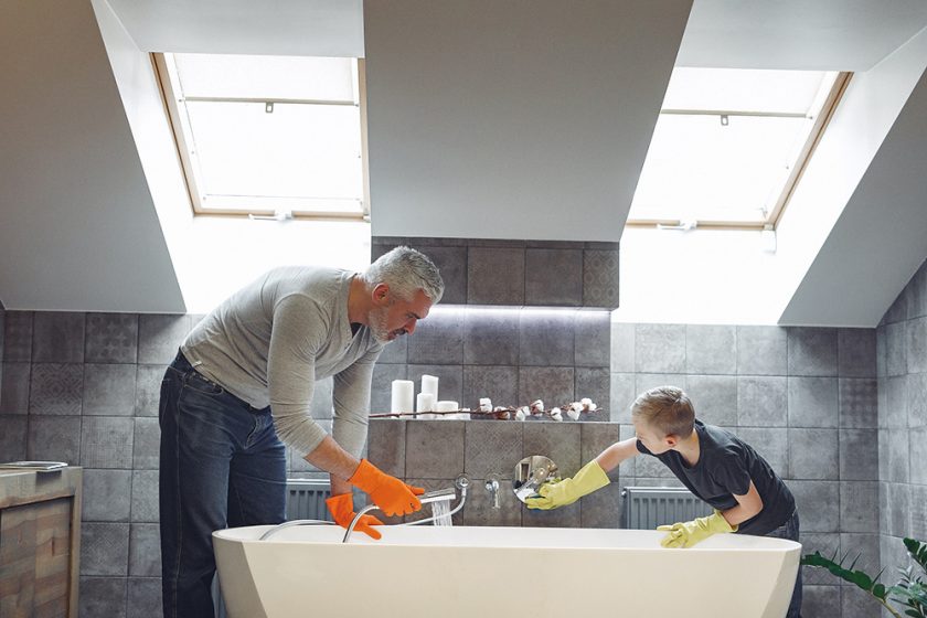 Otec so synom čistia vaňu v kúpeľni