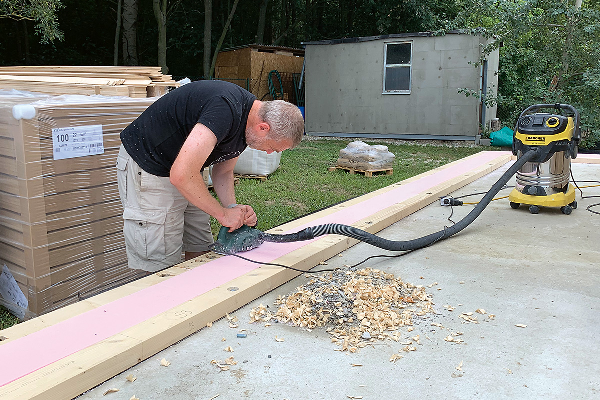 Pred montážou je potrebné pripraviť zateplenú drevenú pásnicu na šírku panelov, ktorá sa ukotví do roviny k základom.