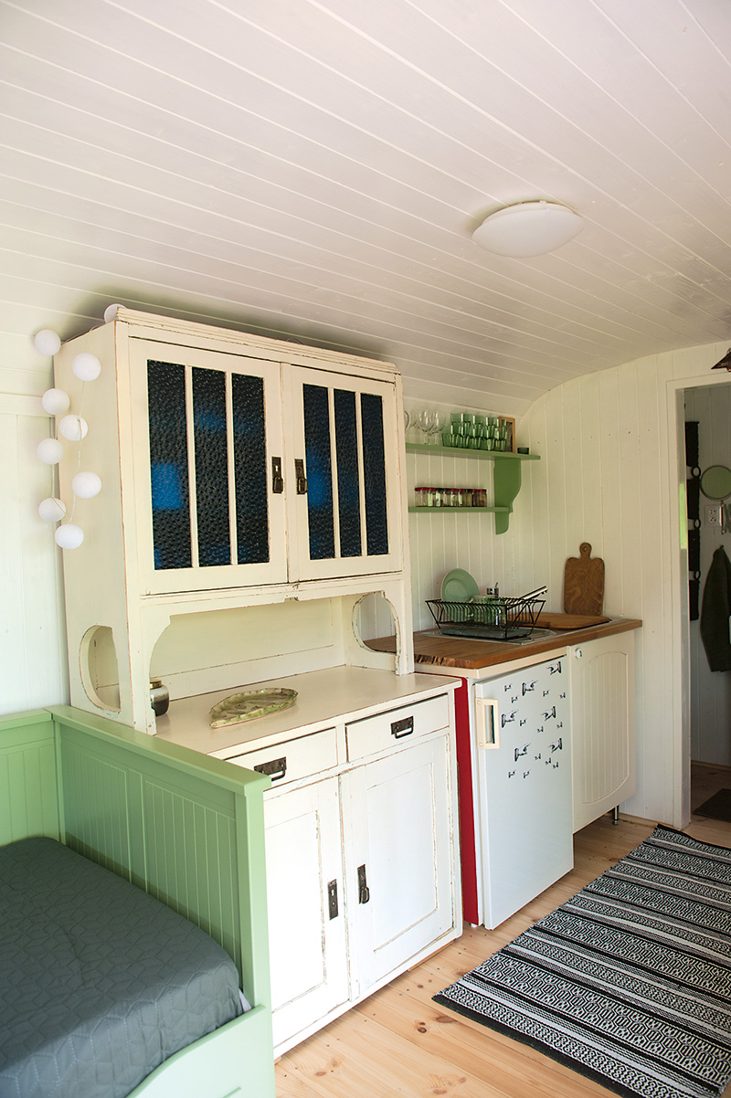 Starý kredenc je dominantou malej kuchyne a zelené doplnky dokonale ladia s celým interiérom.