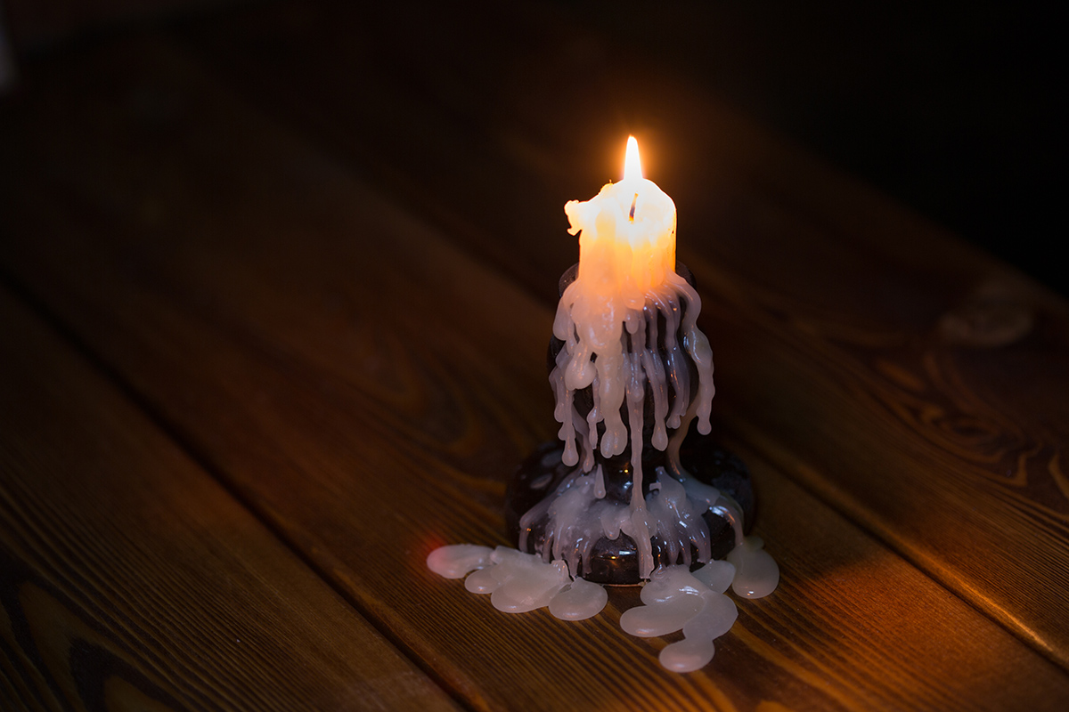 Sviečka vo svietniku so stečeným voskom