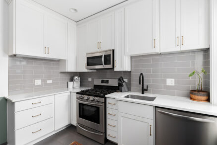 Moderná biela kuchyňa s nerezovými spotrebičmi