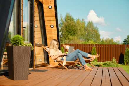 Žena sedí na lehátku pred chatkou na drevenj terase