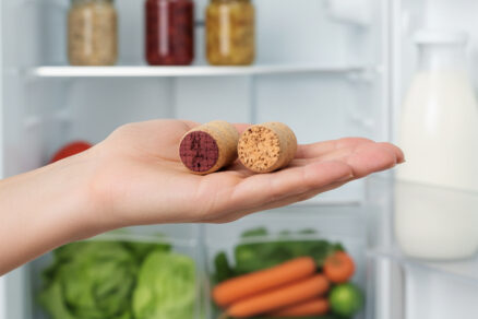 Žena drží korkové zátky pred otvorenou chladničkou, trik proti zápachu
